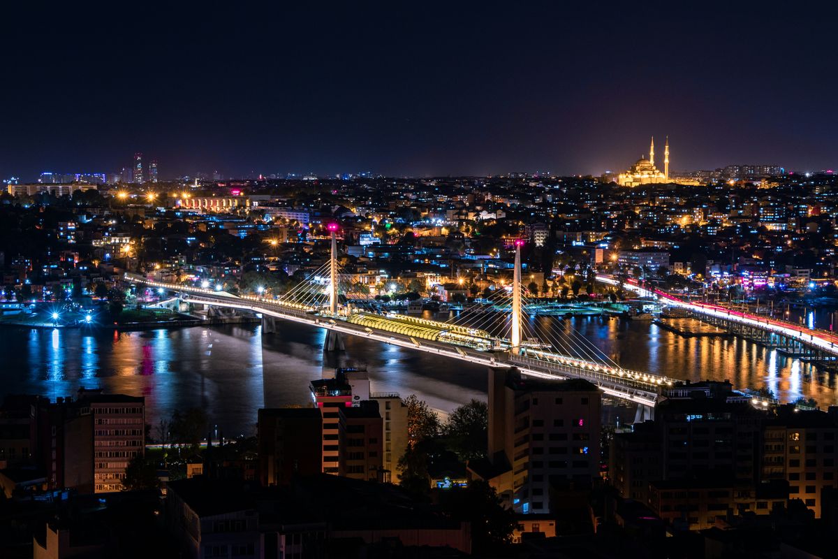 Das Goldene Horn bei Nacht von oben, mit beleuchteter Metrobrücke und der Süleymaniye-Moschee