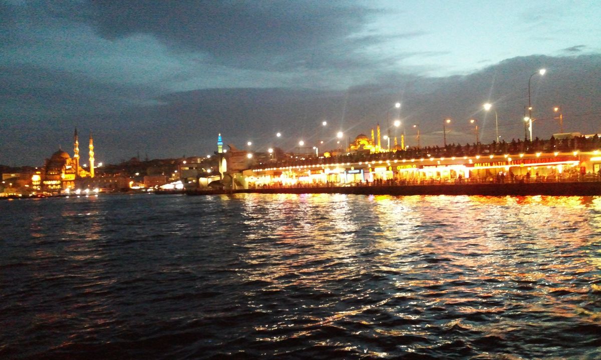Die beleuchtete Galata-Brücke bei Nacht, dahinter die Altstadt