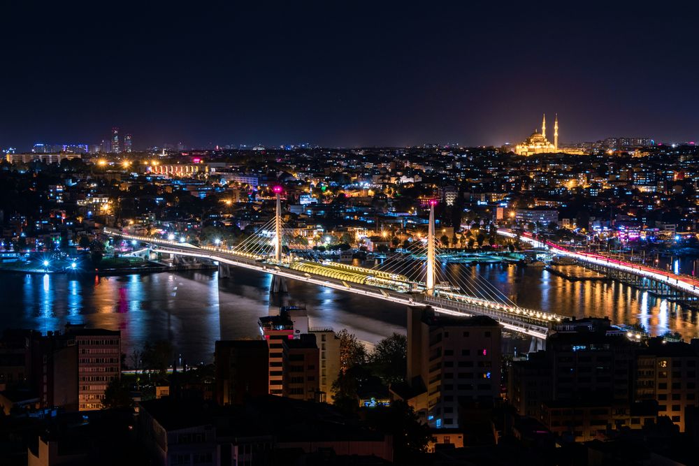 Das Goldene Horn bei Nacht von oben, mit beleuchteter Metrobrücke und der Süleymaniye-Moschee