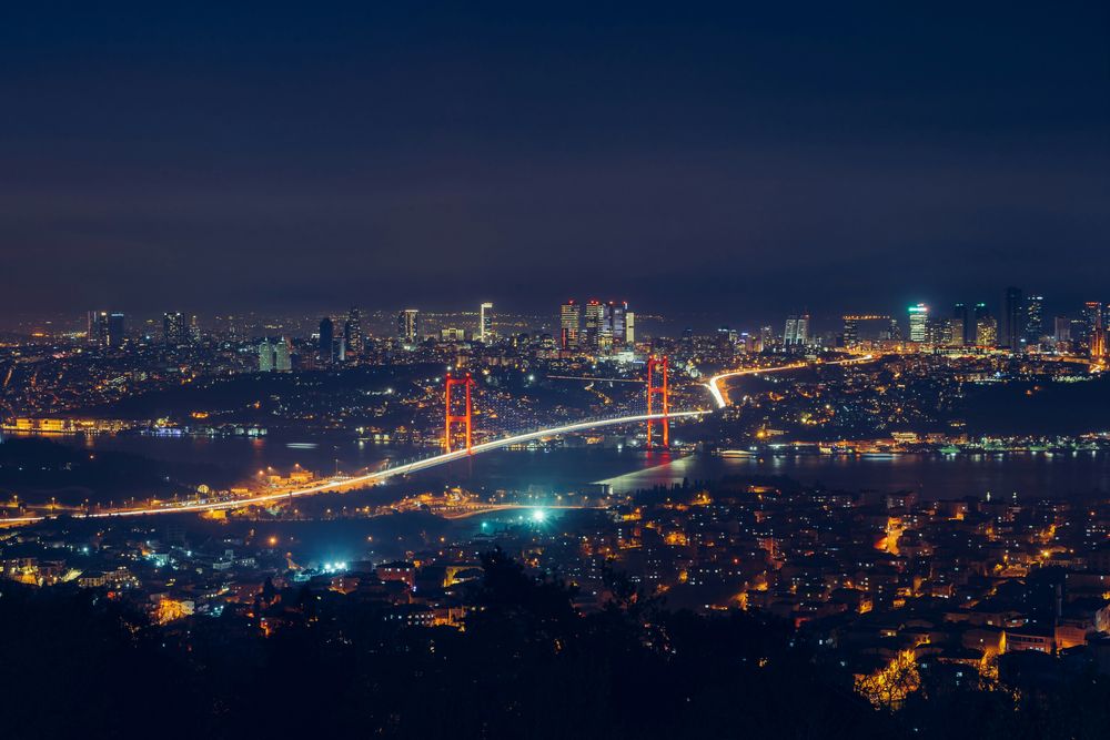 Weites Nachtpanorama über Istanbul mit der beleuchteten Bosporusbrücke und der Skyline